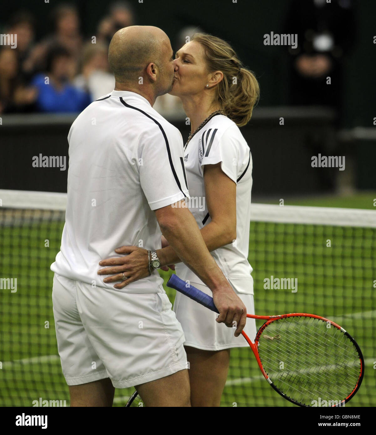 Steffi Graf, ancienne championne de Wimbledon, embrasse son mari et son partenaire Andre Agassi (à gauche) à la fin d'un match d'exposition contre Tim Henman et Kim Clijsters en Grande-Bretagne sur le court central, lors de la célébration du Center court au All England Lawn tennis and Croquet Club, Wimbledon, Londres. Banque D'Images