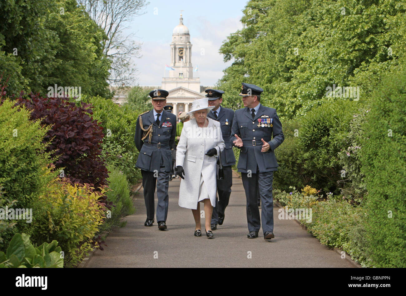 La reine Elizabeth II est accompagnée du duc d'Édimbourg (à gauche) et du capitaine Nigel Warmby, commandant de la station, qui se promène le long de l'avenue Queens à la RAF Cranwell, pendant la revue Queens. Banque D'Images