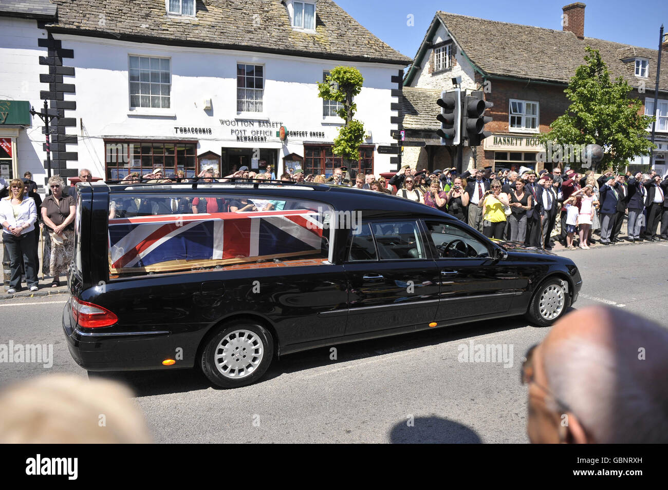 Les amateurs de bourre bordent les rues de Wootton Bassett alors que le corps du caporal Kieron Hill, 20 ans, traverse la ville dans un foyer avec son cercueil couvert par un drapeau syndical après avoir été transporté dans RAF Lyneham, Wiltshire.Le corps du soldat était en route vers l'hôpital John Radcliffe d'Oxford pour un examen post-mortem. Banque D'Images