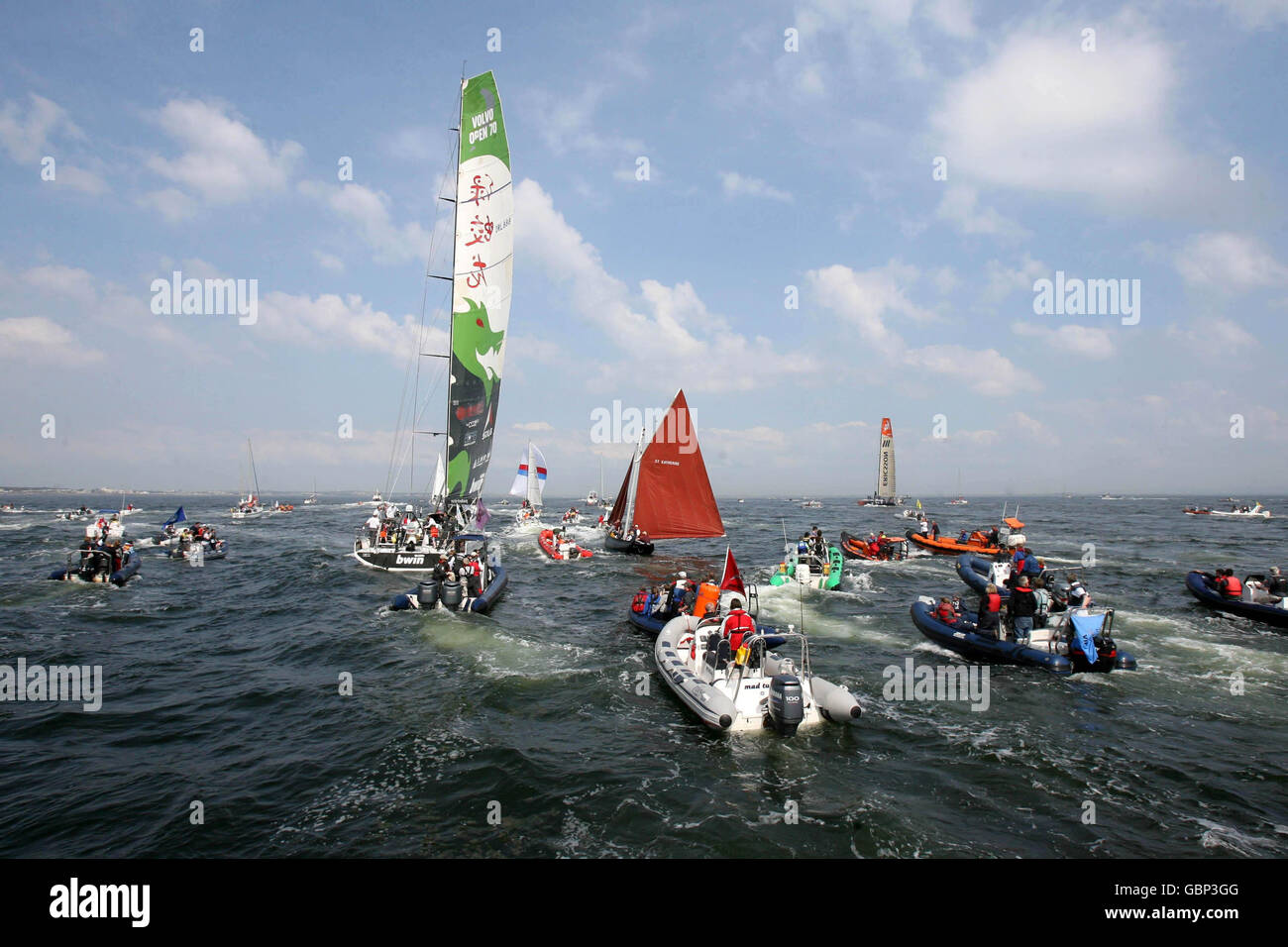 Une armada de petits bateaux suit le Dragon vert de retour au port après la course côtière, puis le deuxième week-end de la Volvo Ocean Race à Galway. Banque D'Images