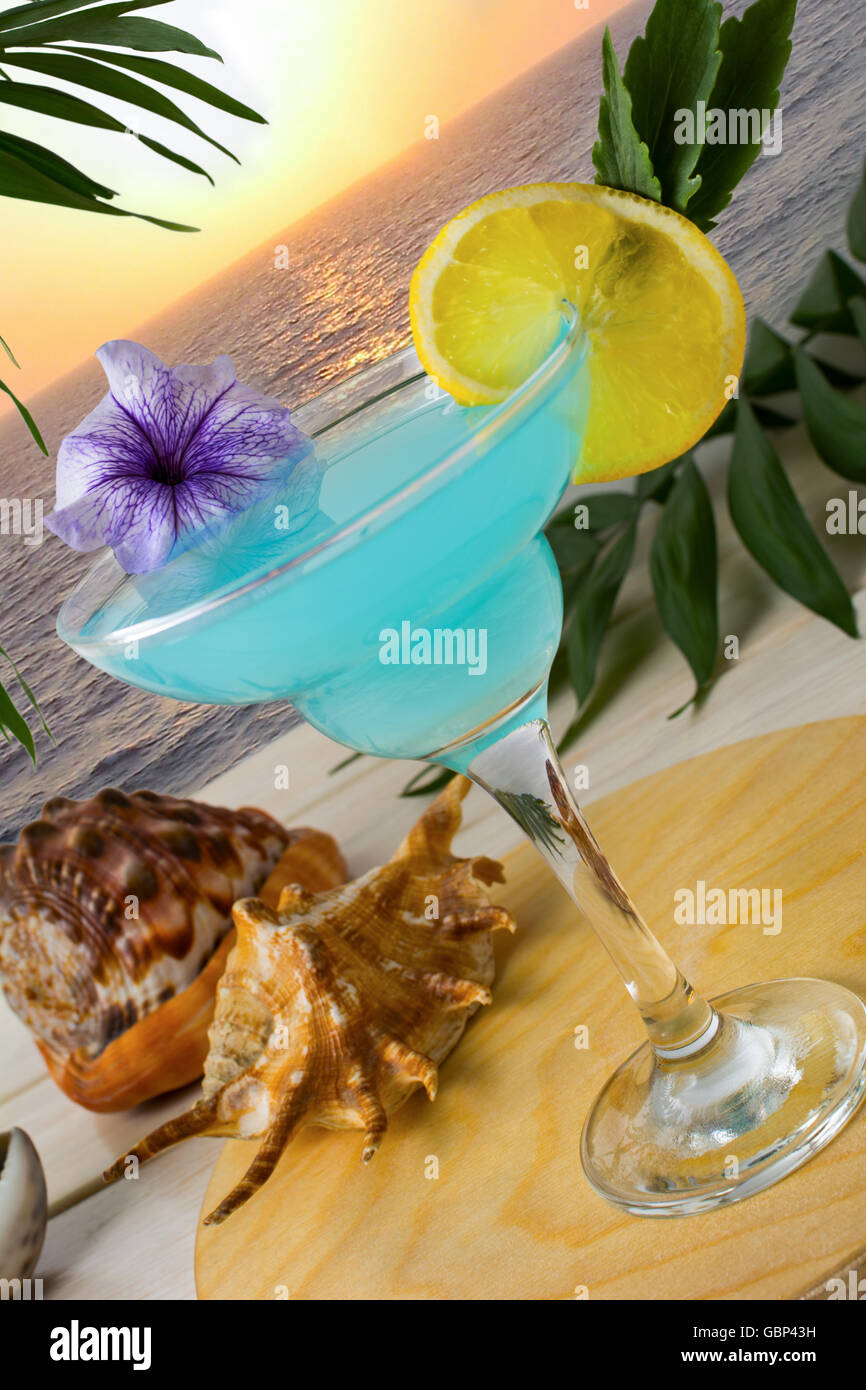 Cocktail bleu sur la mer fond coucher de soleil tropical. Margarita Blue Lagoon cocktail martini. Plage d'été boire de l'alcool. Banque D'Images