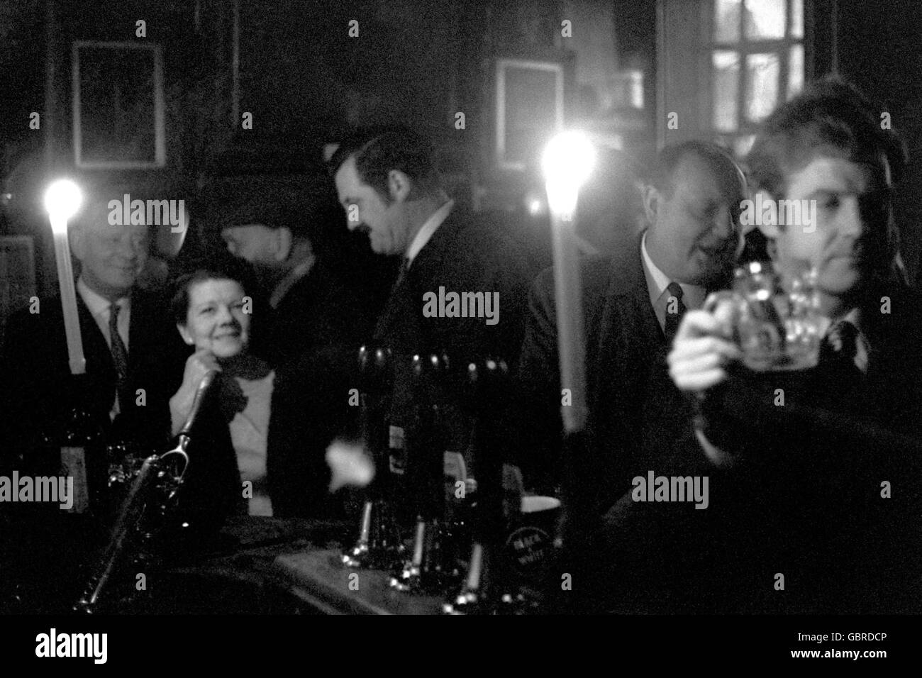 Une pause-repas liquide aux chandelles pour les clients dans une taverne de Fleet Street aujourd'hui, quand des parties de la rue ont été frappées par une coupure de courant. Banque D'Images