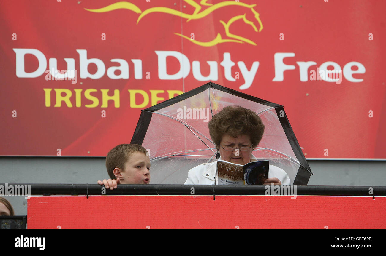 Les punters étudient la forme pendant le Kildare Village Derby Friday à l'hippodrome de Curragh. Banque D'Images