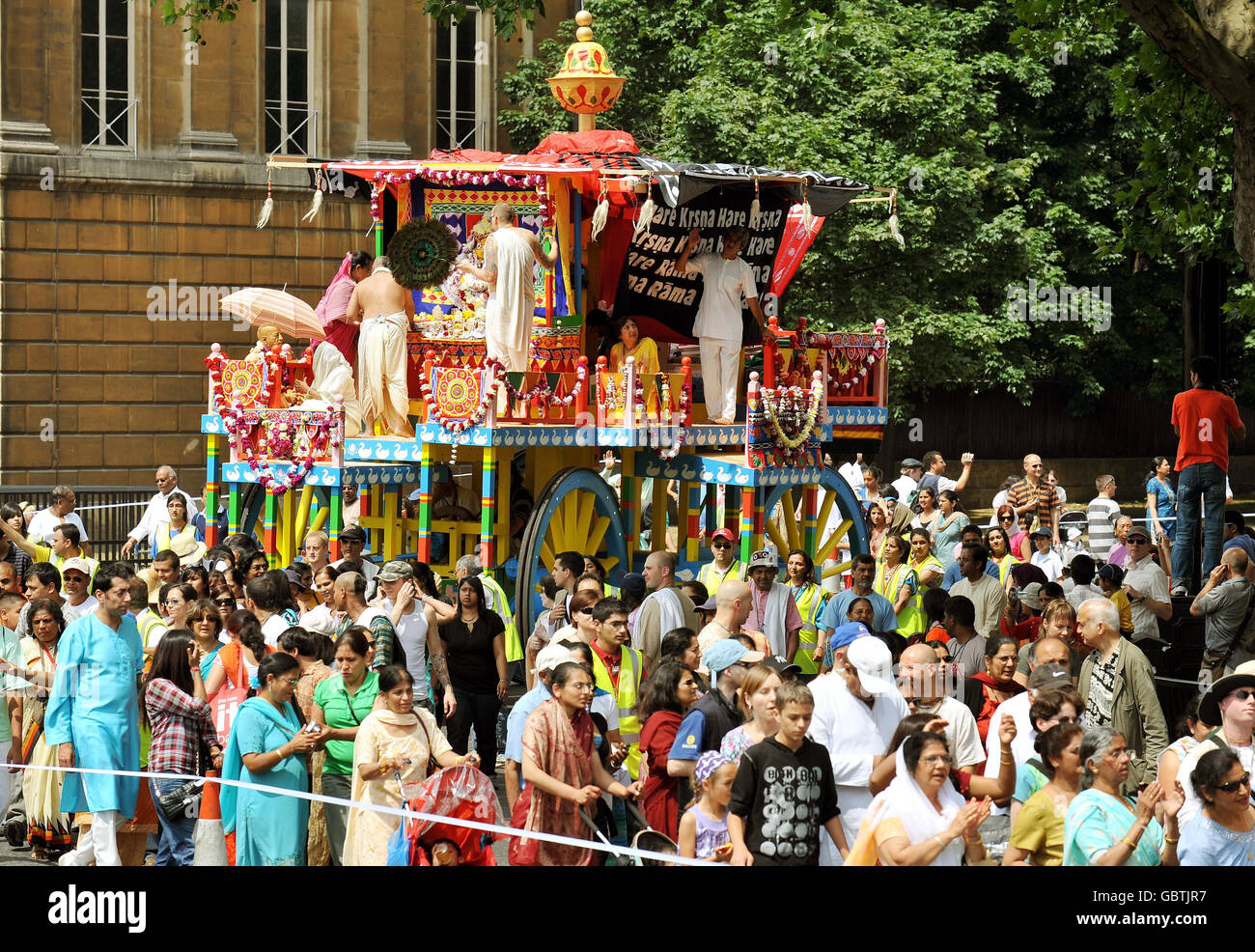 Une petite partie du grand groupe de fidèles Lièvre Krishna, aide à tirer trois grands sanctuaires décoratifs à roulettes, de Hyde Park à Trafalgar Square pour célébrer le festival 'Ratha-yatra'. Banque D'Images