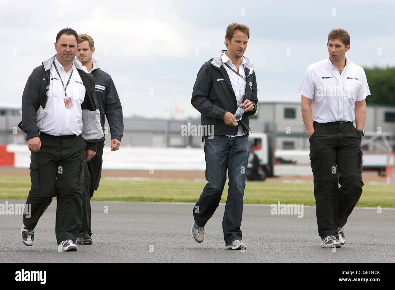 Courses automobiles - Championnat du monde de Formule 1 - Grand Prix de Grande-Bretagne - Paddock Day - Silverstone.Jenson Button (deuxième à droite), en Grande-Bretagne, marche sur la piste pendant le Paddock Day à Silverstone, dans le Northamptonshire. Banque D'Images