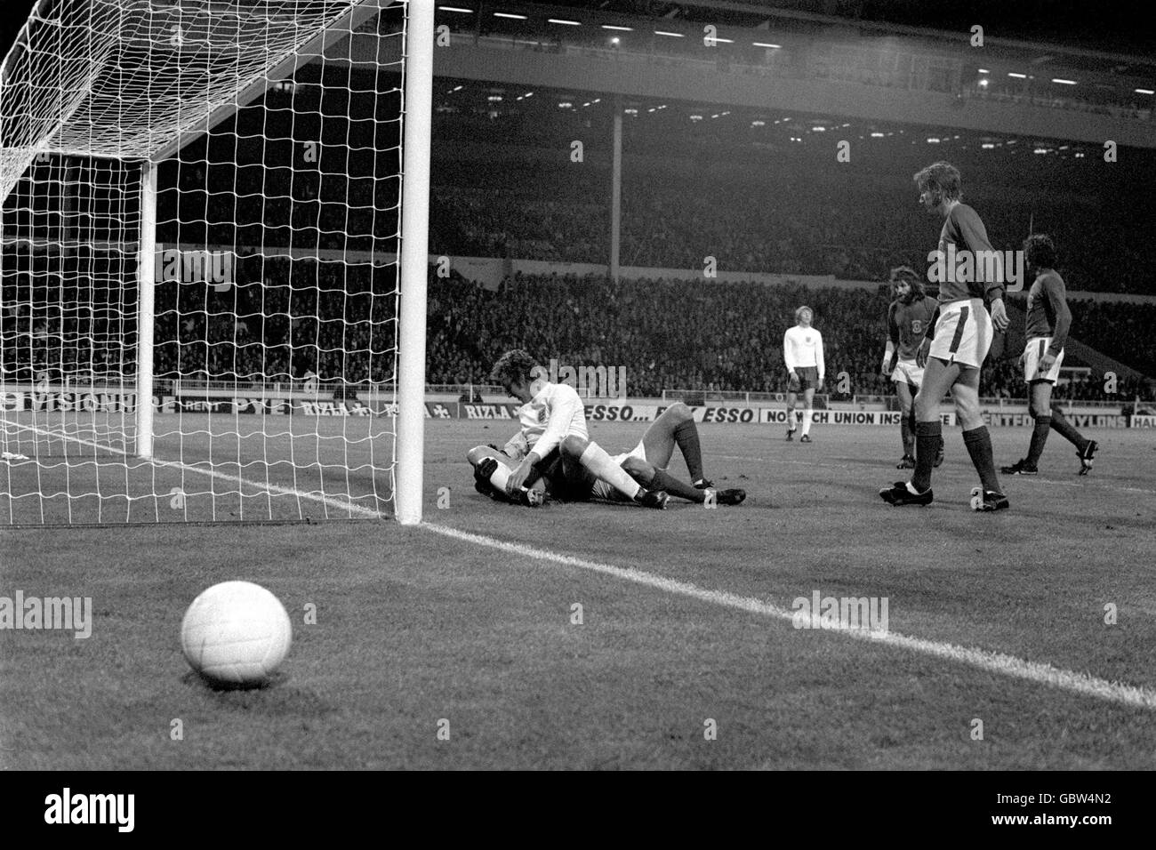 Martin Chivers, en Angleterre, est au sommet de John Phillips, gardien de but du pays de Galles, tandis que le ballon s'étend Banque D'Images