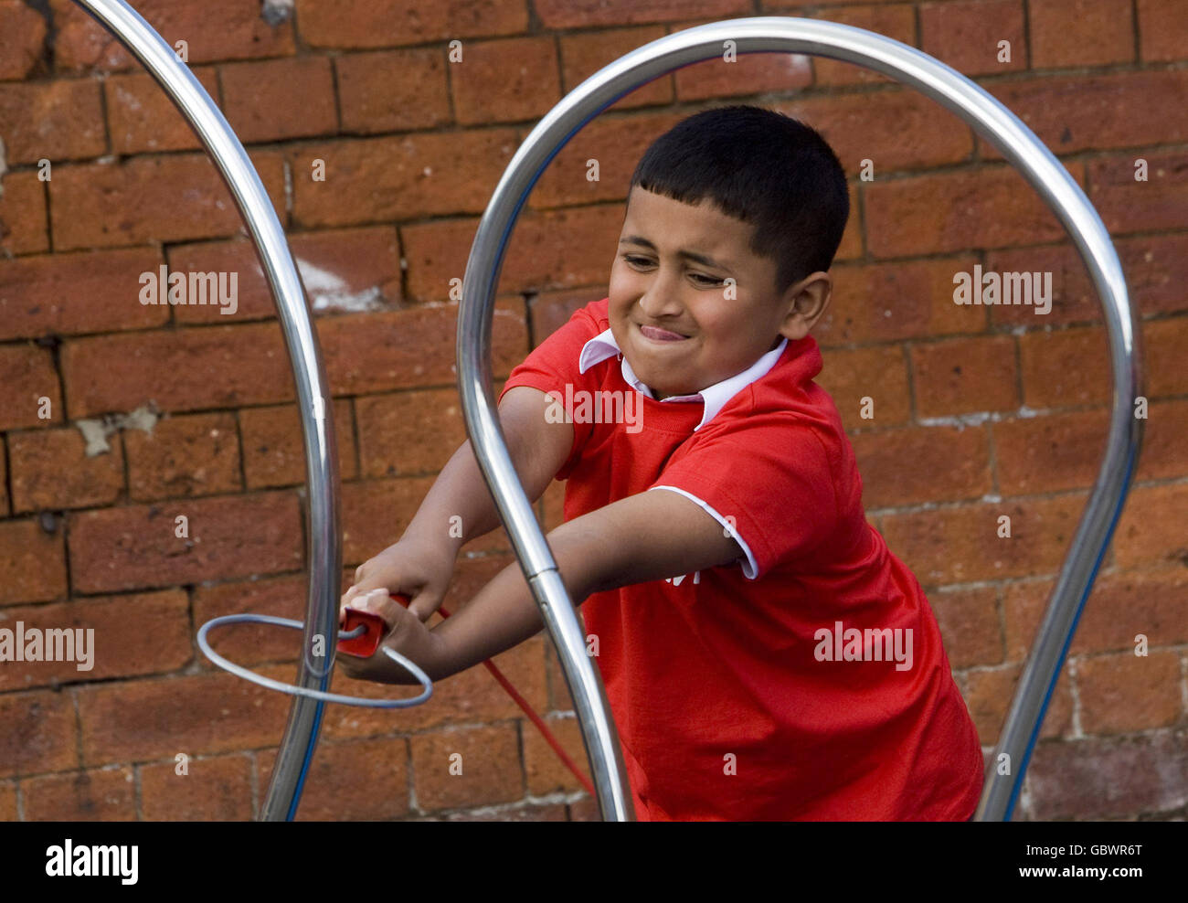 Zain Farooq (8) de l'école primaire Clarendon à Bolton essayant le jeu de bruiteur électrique à pédale géant lors d'un cours de science en plein air qui fait partie du programme interactif d'éducation Energy Experience d'E.ON enseignant aux enfants l'énergie renouvelable. Banque D'Images