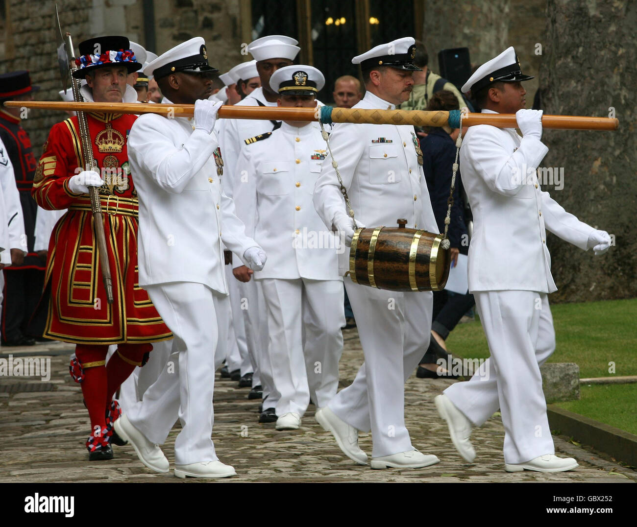 L'équipage de l'USS Halyburton est surveillé par un Beefeater sur Tower Green, la Tour de Londres après avoir été autorisé par le Yéoman Jailer avec un fût de vin. Banque D'Images