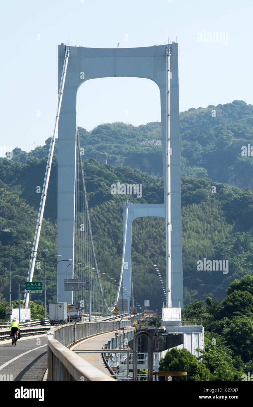 Deux cyclistes traversant le OshimaBridge Hakata reliant les îles d'Oshima et Hakata dans la mer intérieure de Seto. Banque D'Images