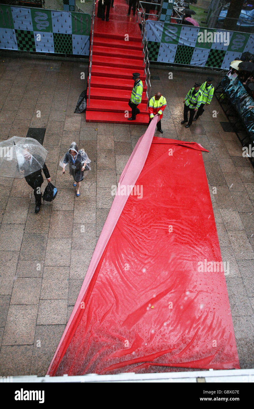 Le tapis rouge est enlevé lors de la douche à forte pluie à la première mondiale de Harry Potter et le Prince de sang-mêlé à l'Odeon Leicester Square, Londres. Banque D'Images