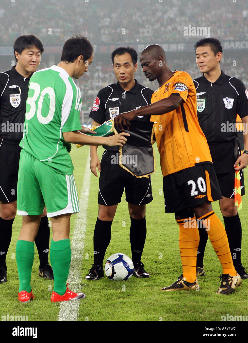 Les capitaines de Beijing Guoan Zhang Yonghai (2e à gauche) et George Boateng de Hull City (2e à droite) échangent des pennants avant leur match de football Asia Trophy au Worker's Stadium de Beijing, en Chine Banque D'Images