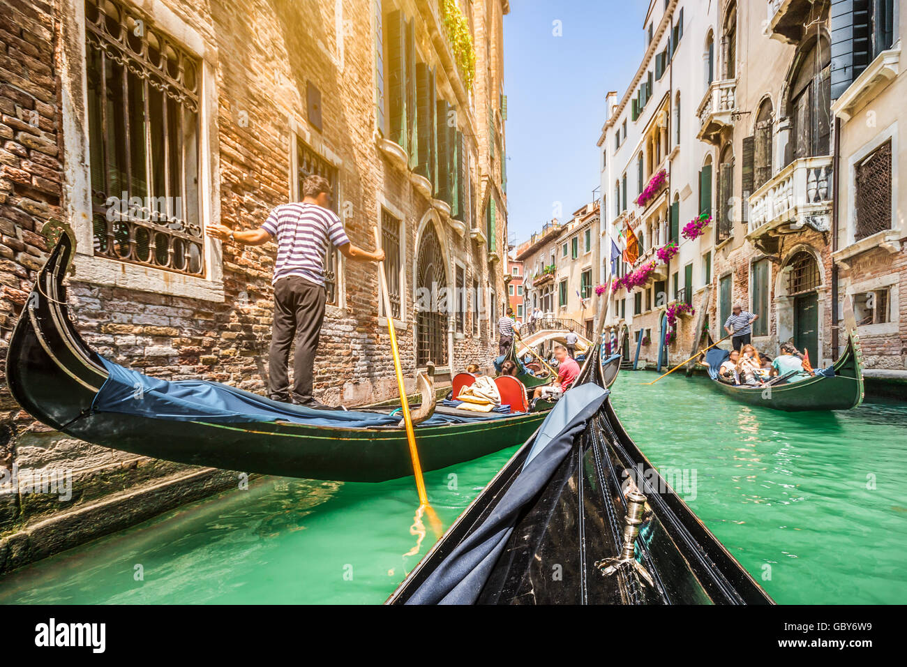 Gondoles sur canal in Venice, Italie avec retro vintage style Instagram et lens flare filtre effet de soleil en été Banque D'Images