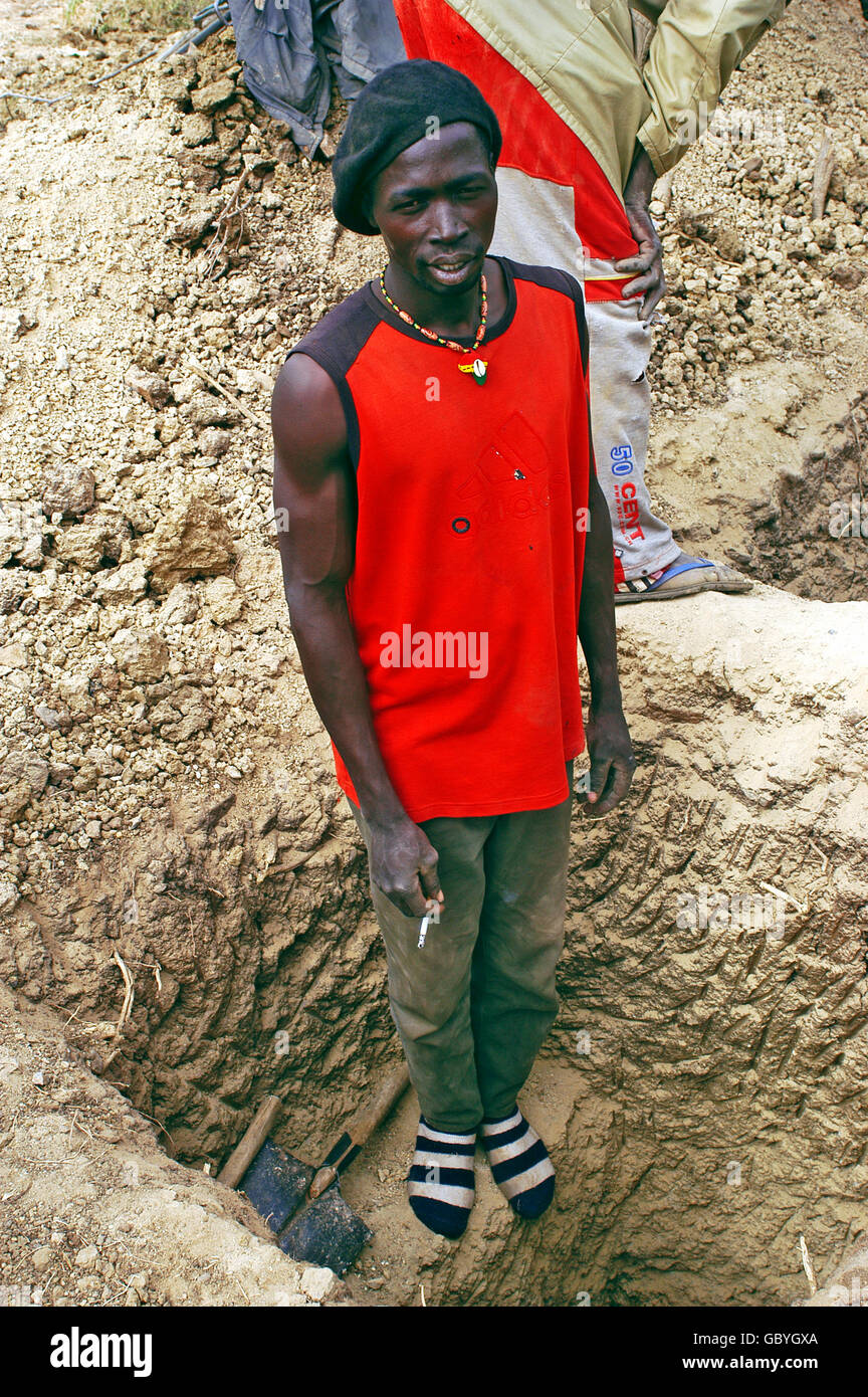 L'Afrique de mineur d'or de s'arrêter pour fumer sa cigarette mine d'où il travaille Banque D'Images
