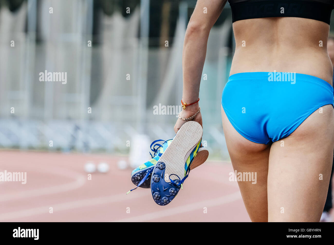 Girl runner tient en mains spike chaussures de course après course de sprint Banque D'Images