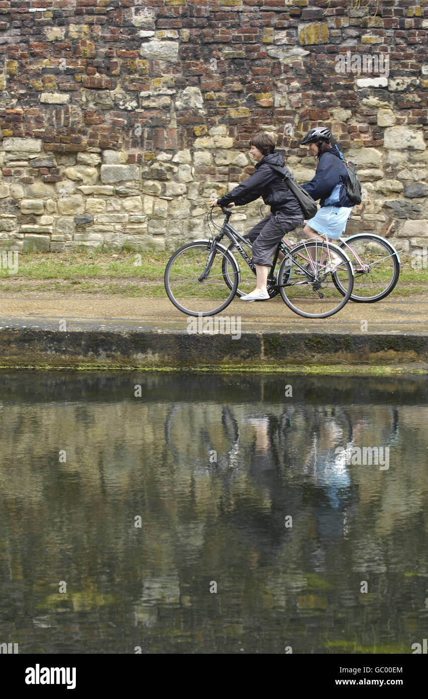 Deux cyclistes se trouvent sur la piste de remorquage du Regent's Canal, dans l'est de Londres. Banque D'Images