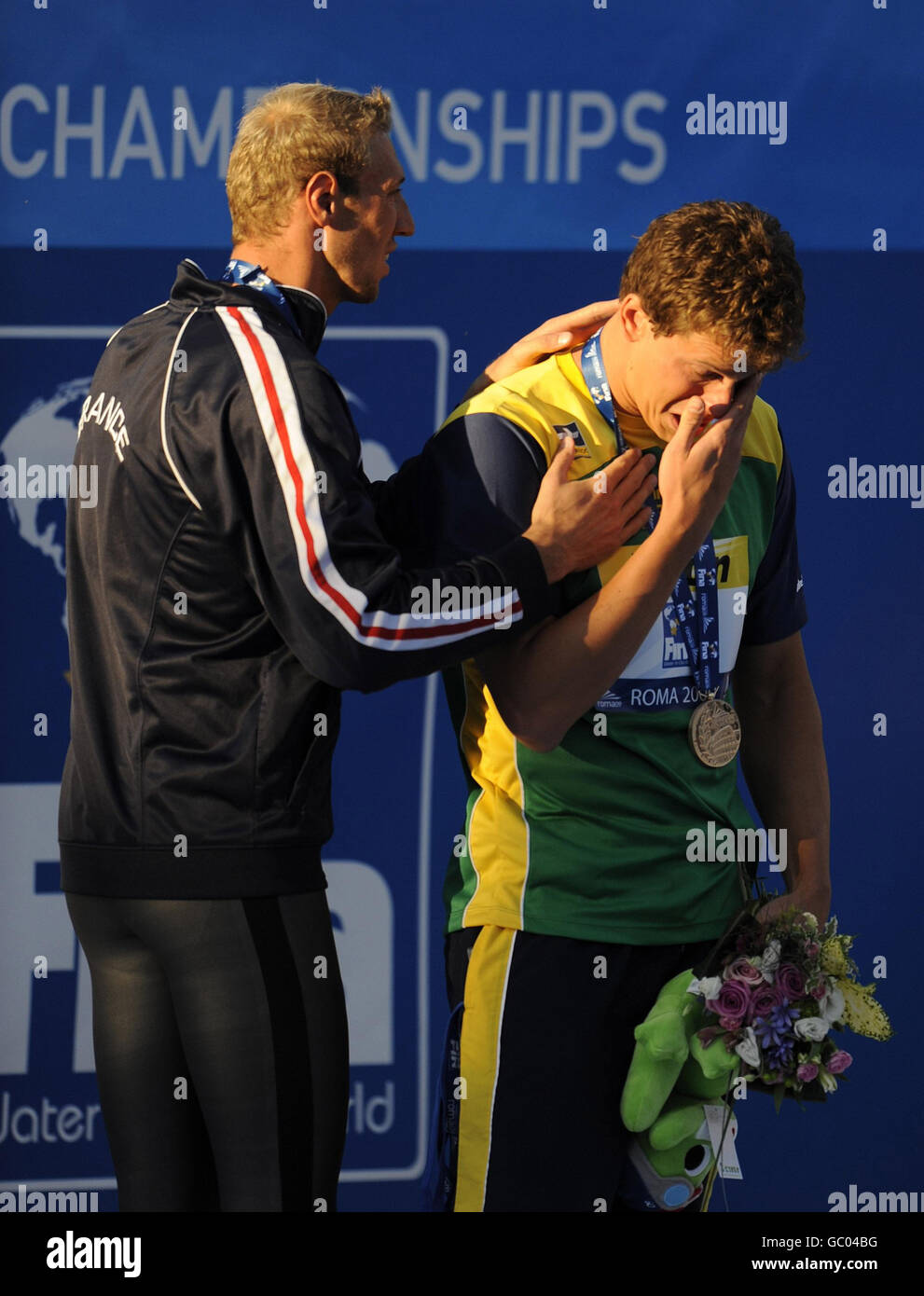 Le brésilien Cesar Cielo Filho pleure lors de la cérémonie de remise des médailles avec Alain Bernard, médaillé d'argent français (à gauche), après avoir remporté la finale Freestyle de 100 m masculin lors des Championnats du monde de natation de la FINA à Rome, en Italie. Banque D'Images