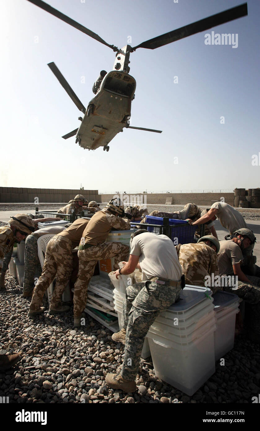 Les troupes britanniques et américaines de Lashkar Gah, en Afghanistan, maintiennent des urnes pour la plupart vides de Sangin, pour les empêcher de se déverser dans le courant descendant d'un Chinook, après qu'une faible participation ait été signalée dans le district de Sangin. Banque D'Images