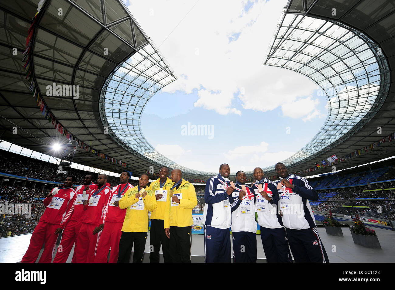 Usain Bolt se tient au milieu tandis que l'équipe de relais jamaïcaine collectionne leurs médailles d'or du relais masculin 4x100 dans lequel la Grande-Bretagne (à droite) a remporté la médaille de bronze lors des Championnats du monde de l'IAAF à l'Olympiastadion, à Berlin. Banque D'Images