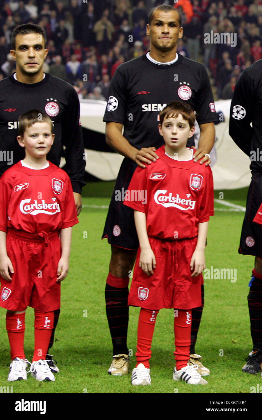 Football - Ligue des champions de l'UEFA - Groupe A - Liverpool v Olympiakos. Les mascottes s'alignent avec les joueurs avant le lancement Banque D'Images