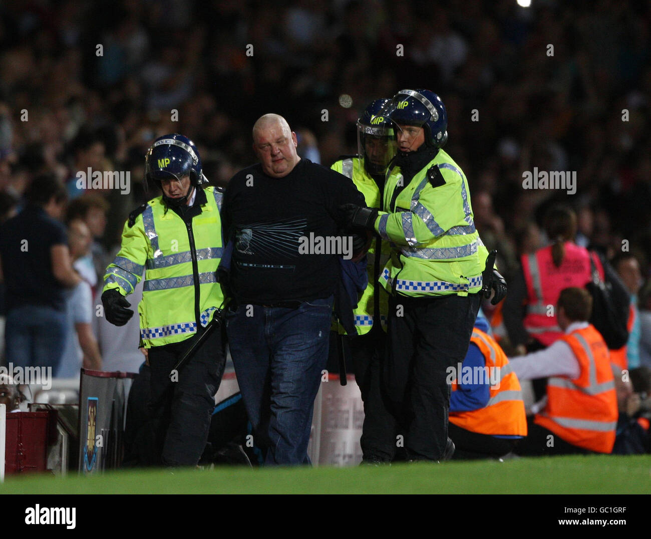 Un fan est conduit par la police anti-émeute lors du deuxième tour de la Carling Cup à Upton Park, Londres. Banque D'Images