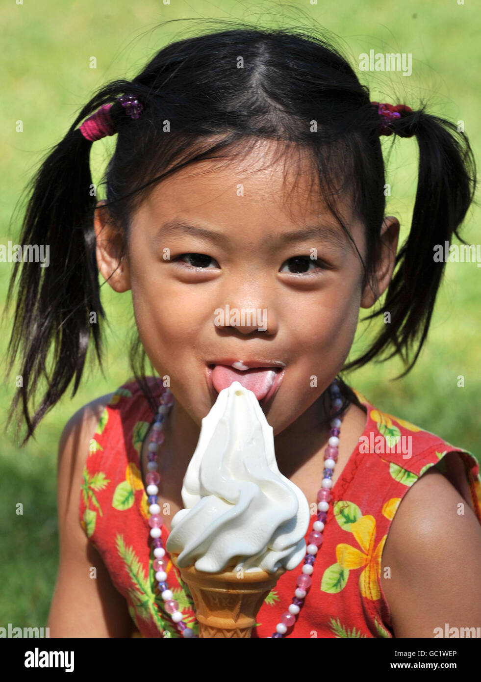 Lily Mei, âgée de quatre ans, originaire de Chine, bénéficie d'une glace dans le parc St James's de Londres, tandis que le temps chaud se poursuit dans la capitale. Banque D'Images