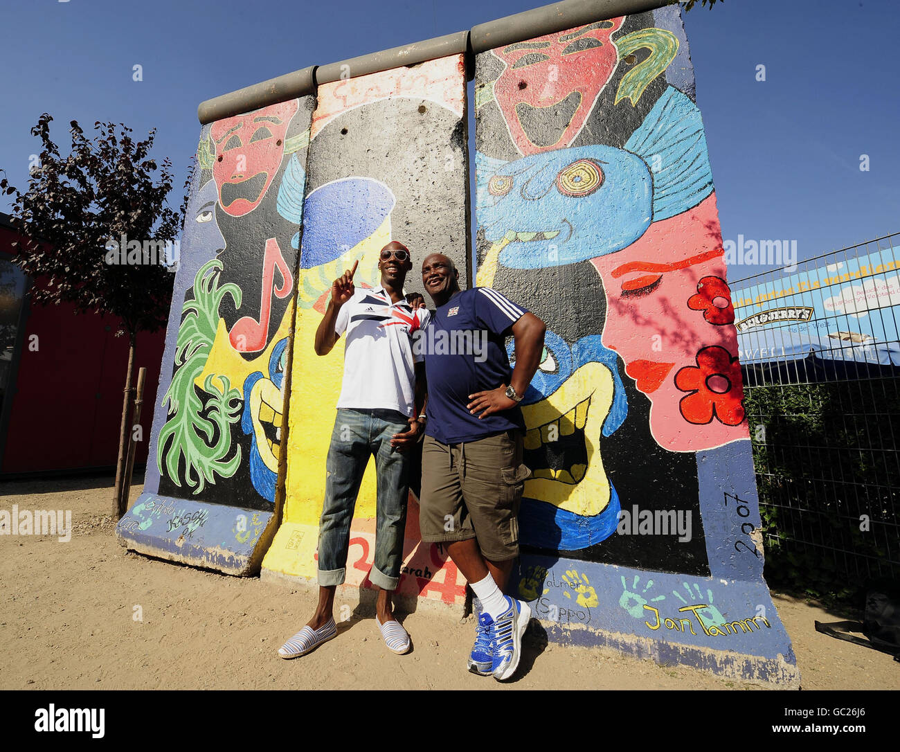 Le Phillips Idowu de Grande-Bretagne pose avec son entraîneur Aston Moore, pour les médias au mur de Berlin après qu'il ait tenu une conférence de presse sur un bus en plein air lors des championnats du monde de l'IAAF à l'Olympiastadion, à Berlin. Banque D'Images