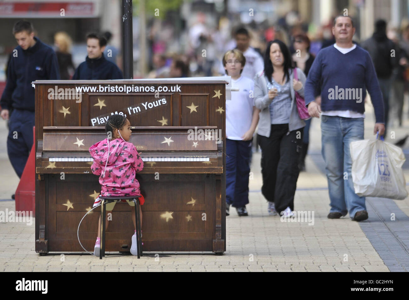 Ashanti James, 4 ans, de Fishmares, joue un piano solitaire dans le centre de Broadmead, le principal quartier commerçant de Bristol, qui fait partie d'une installation d'art intitulée « Play Me » par l'artiste de Bristol Luke Jerram. Banque D'Images