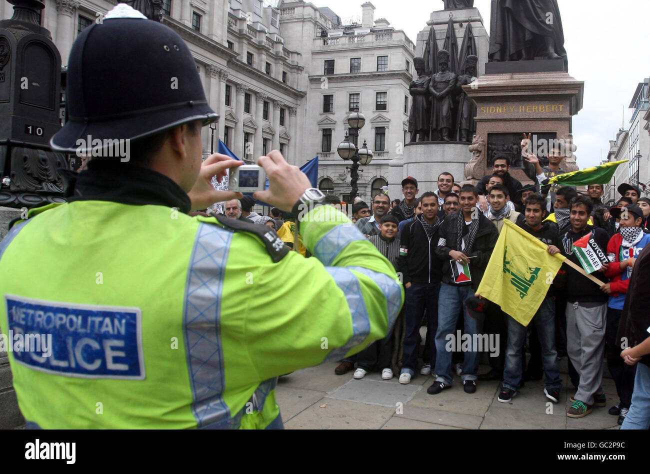 Un policier prend une photo des manifestants lors de la procession et de la manifestation annuelle du jour Al-Quds dans le centre de Londres. Banque D'Images