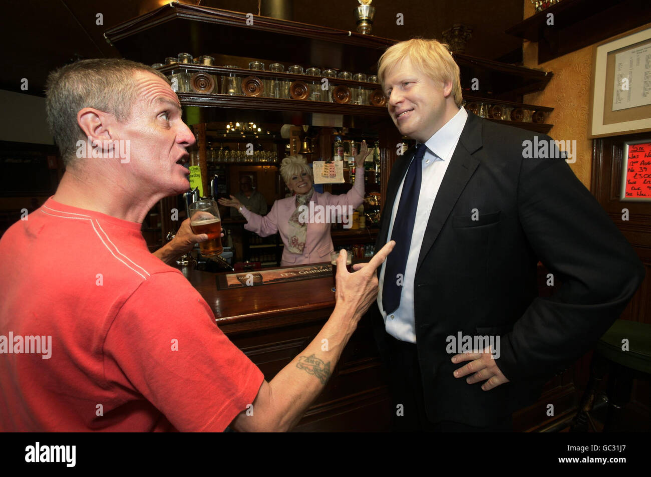 Les modèles de cire du maire de Londres Boris Johnson (qui fait une apparition sur BBC SOAP Eastenders demain) et Barbara Windsor, en tant que personnage Peggy Mitchell, sont placés dans le pub Queen Victoria à Southwark, Londres, avec le client local Stephen Salmon. Banque D'Images