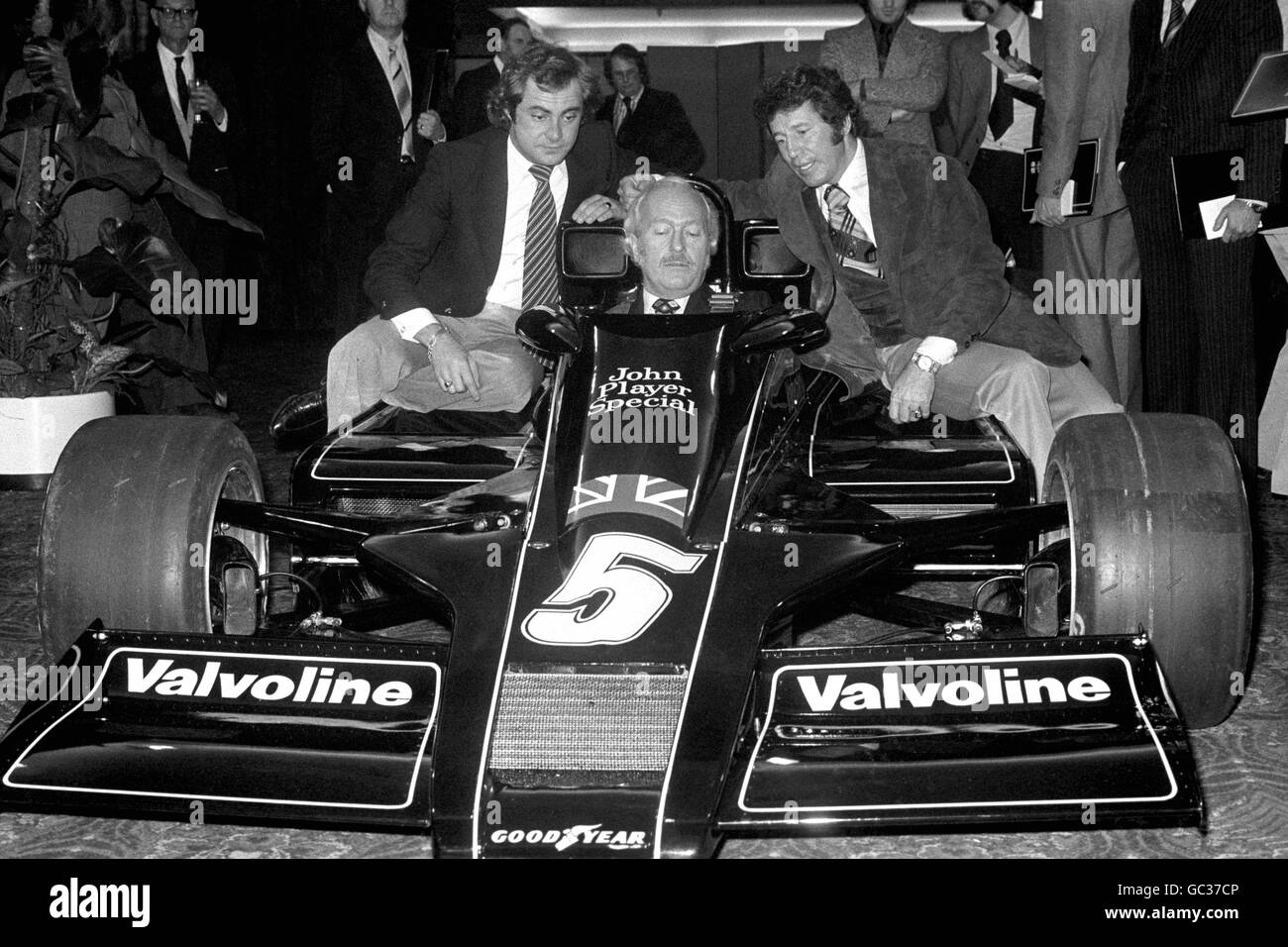 Le nouveau Lotus 78 (nommé le John Player Special Mk. III) est dévoilé aux médias lors de son lancement au Royal Garden Hotel de Londres. Colin Chapman, le chef du Lotus, est assis dans la nouvelle voiture, flanquée des pilotes Mario Andretti (à droite) et Gunnar Nilsson Banque D'Images