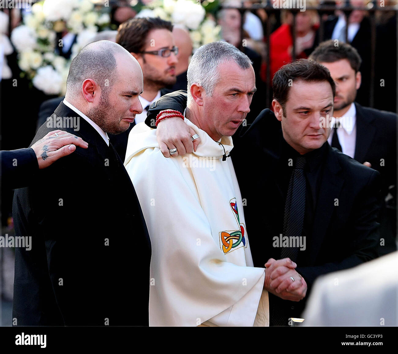 Mikey Graham est réconforté par le Père Declan Blake et Mark Gately(à gauche), le frère de Stephen Gately à l'extérieur de l'église St Laurence O'Toole à Dublin, où les funérailles du membre Boyzone ont eu lieu. Banque D'Images