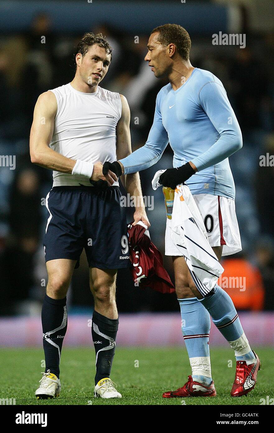 Johan Elmander de Bolton Wanderers (à gauche) serre la main avec John Carew (à droite) de Aston Villa après le sifflet final. Banque D'Images