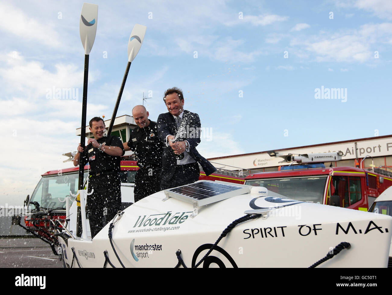 Le MD Andrew Cornish (à droite) de l'aéroport de Manchester a célébré à bord du bateau « The Spirit of ma » qui doit être navigué par Dean Jagger (à gauche) et Neil Gllyhip.Dean et Neil feront le tour du bateau de 30 pieds dans l'océan Atlantique en décembre. Banque D'Images