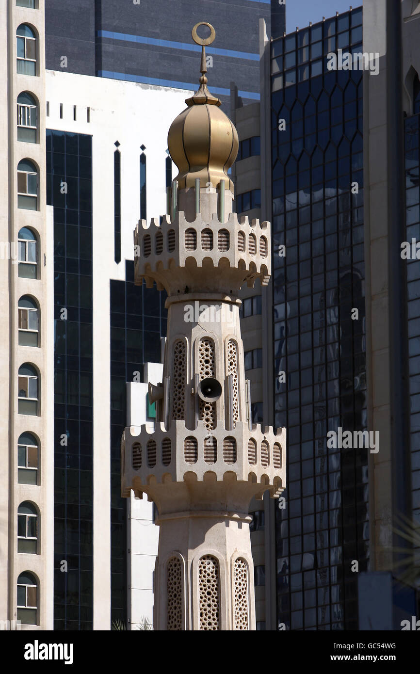 Le minaret d'une mosquée se trouve en face d'un immeuble de bureaux dans le centre-ville d'Abu Dhabi, aux Émirats arabes Unis Banque D'Images