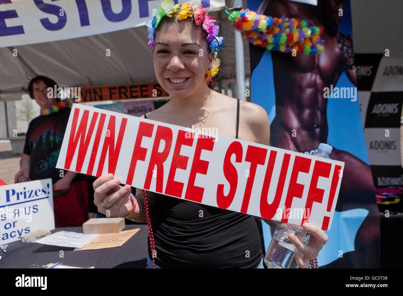 La promotion féminine model holding 'Win Free stuff' signe à un festival culturel en plein air - USA Banque D'Images