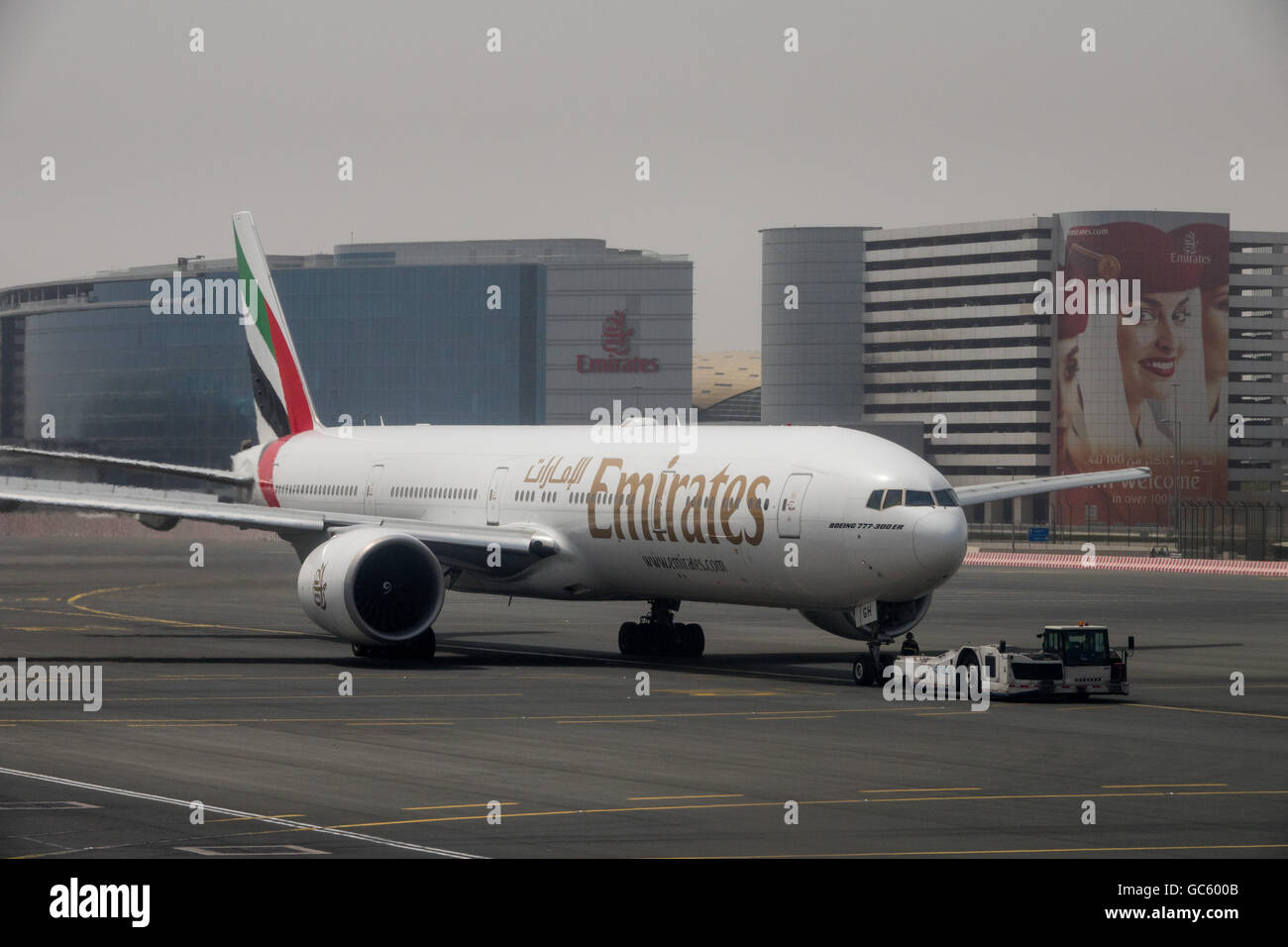 Un Boeing 777-300ER Emirates repousse à partir de la porte à l'Aéroport International de Dubaï Banque D'Images