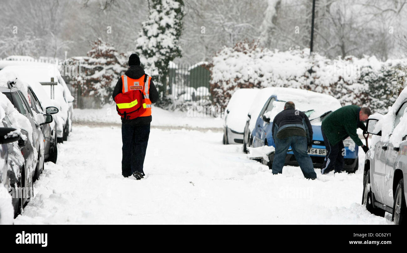 Un postier se rend dans la neige lors de son tour à Altrincham, dans le Cheshire, alors que les conditions arctiques ont forcé la fermeture d'écoles, de routes et d'aéroports. Banque D'Images