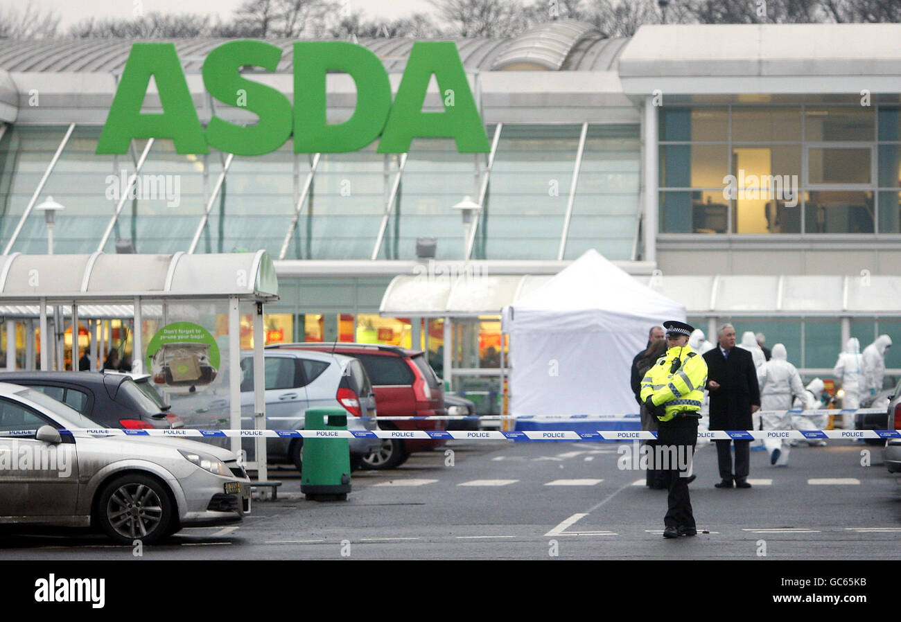 Homme abattu dans le parking du supermarché.Des policiers et des médecins légistes sur les lieux d'une fusillade fatale près d'un magasin de l'ASDA à Glasgow. Banque D'Images