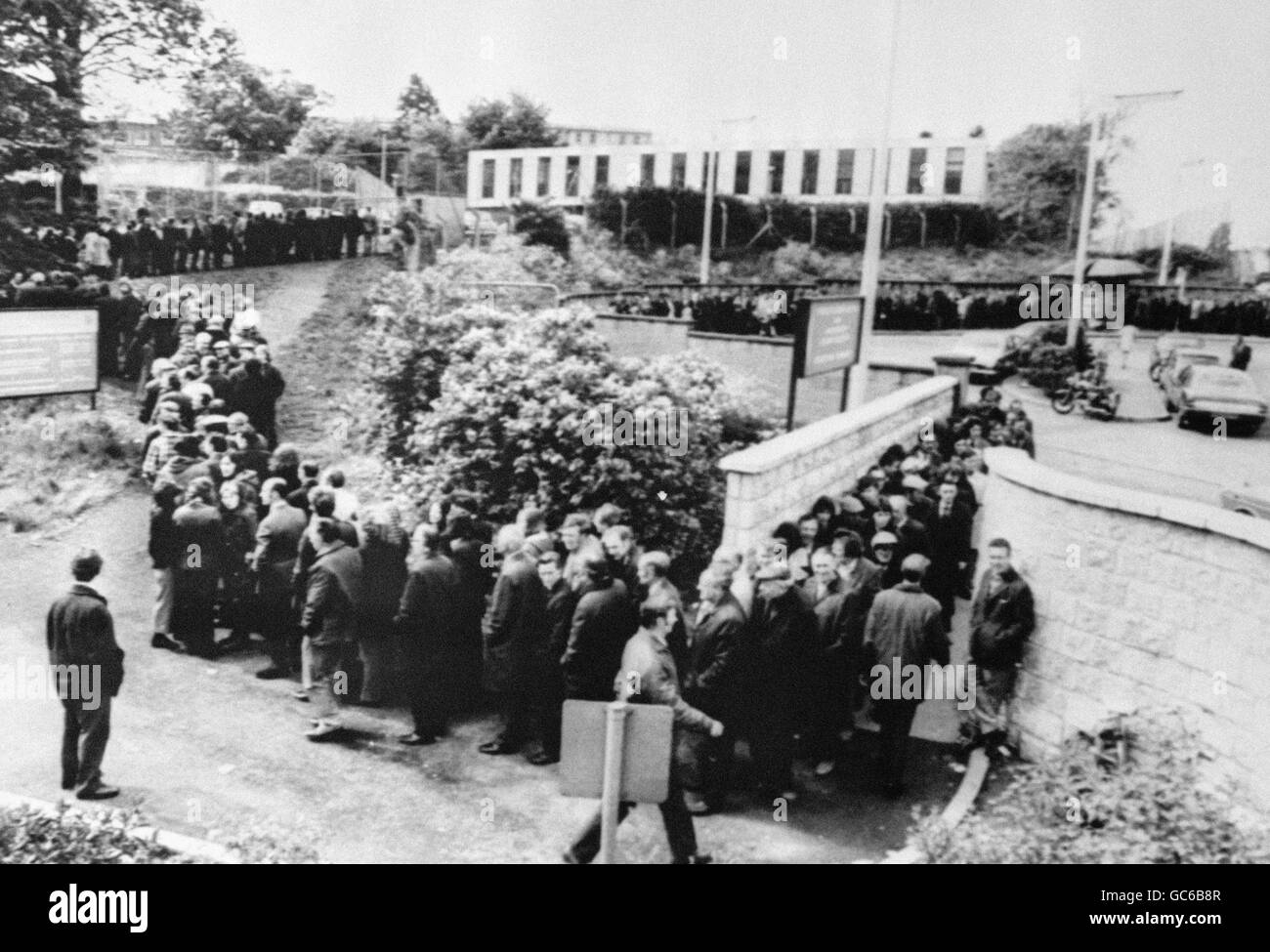 Les prestataires de prestations de chômage forment une file d'attente qui s'étend hors de vue en dehors de l'échange d'emploi dans la banlieue de Belfast, à Newtownbreda. Banque D'Images