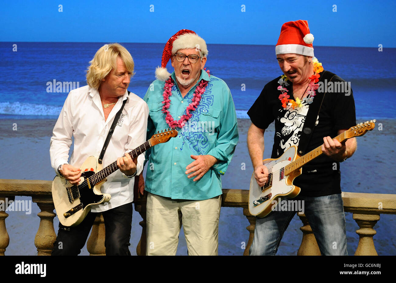 (De gauche à droite) Rick Parfitt, Rolf Harris et Wayne Morris filme la vidéo pour leur nouveau single Christmas in the Sun, aux Shepperton Studios de Twickenham. Banque D'Images