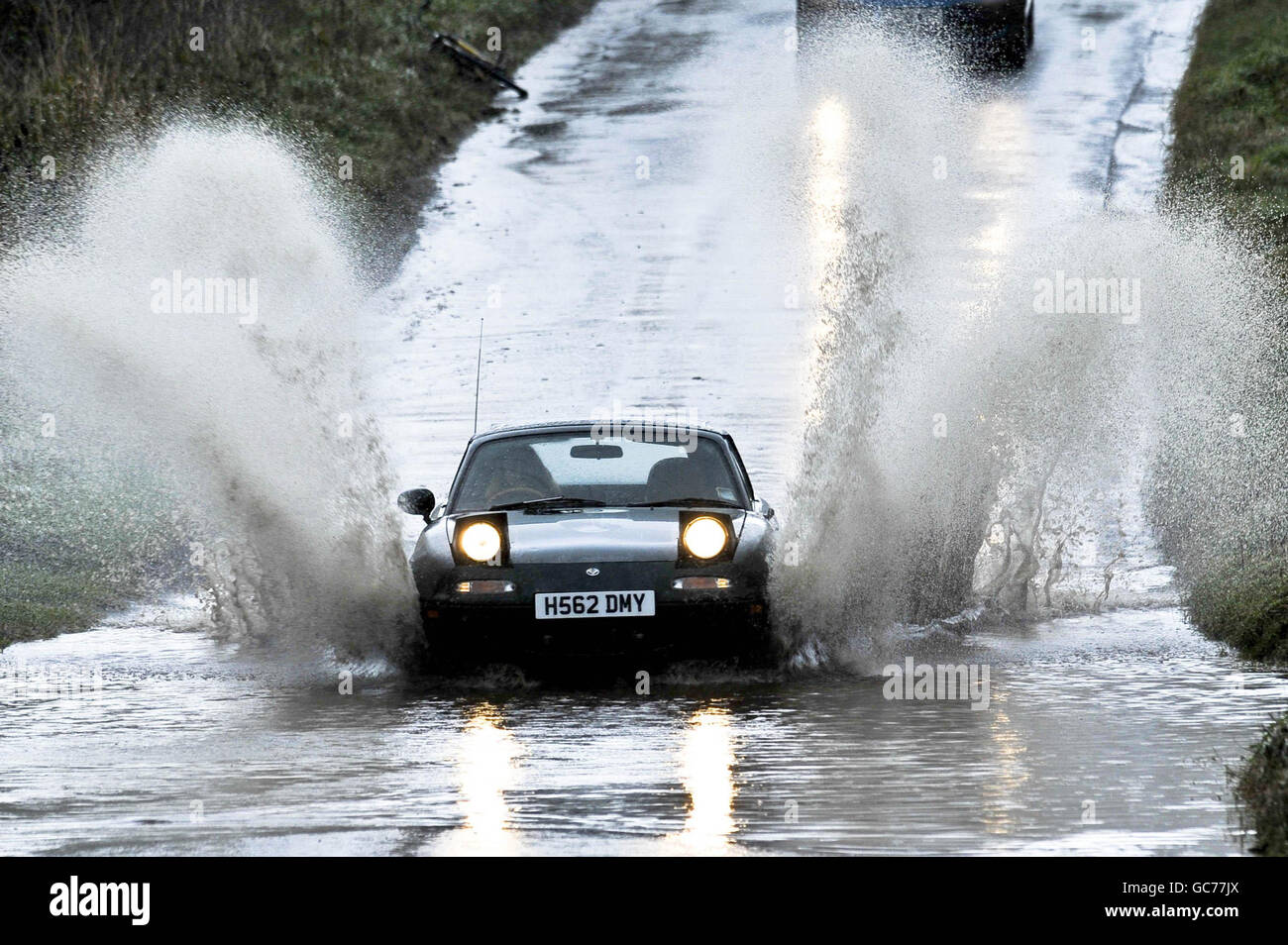 Une voiture traverse une route inondée dans le Somerset après deux jours de forte pluie. Les routes du comté ont une eau stagnante étendue et des zones inondées localisées après ce qui a été l'un des Novembers les plus humides jamais enregistré. Banque D'Images