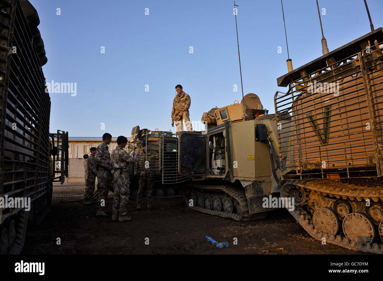 Un soldat du 1er Régiment de chars royal du D Squadron se tient au-dessus d'un véhicule Viking au Camp Bastion dans la province de Helmand, en Afghanistan, alors qu'ils préparent les véhicules et l'équipement prêt à quitter le camp et à aller vers les bases d'opération Forward. Banque D'Images