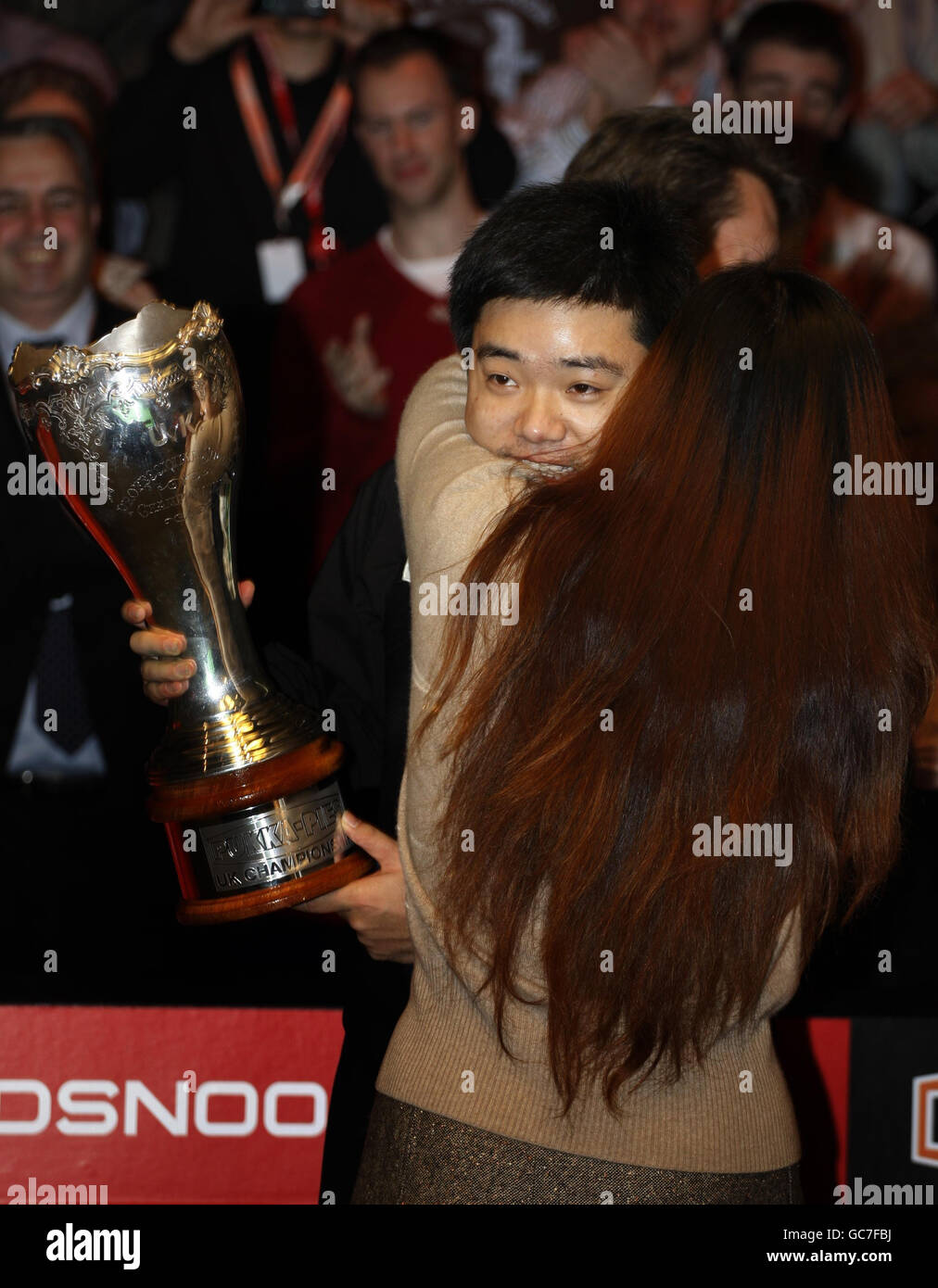 Le Ding Junhui en Chine célèbre avec sa mère Chen XiJuan lorsqu'il lève le Trophée après avoir battu le John Higgins 10-8 en Écosse lors de la finale du championnat britannique Pukka Pies au Telford International Center, à Telford. Banque D'Images