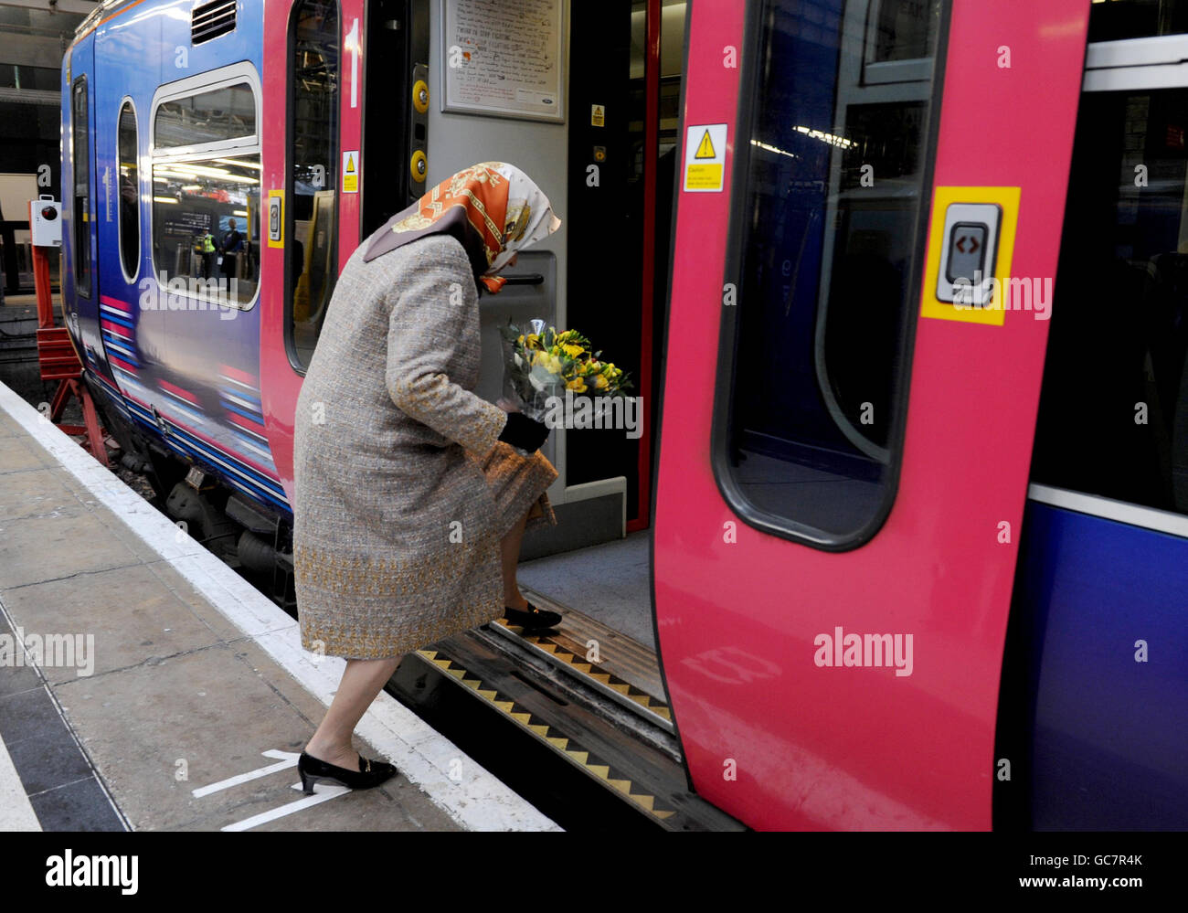 La reine Elizabeth II de Grande-Bretagne monte à bord d'un train First Capital Connect pour partir de la gare de Kings Cross à Londres, d'où elle a voyagé par service régulier à Kings Lynn à Norfolk. Elle se rendra plus tard à Sandringham où elle passera Noël avec sa famille. Banque D'Images