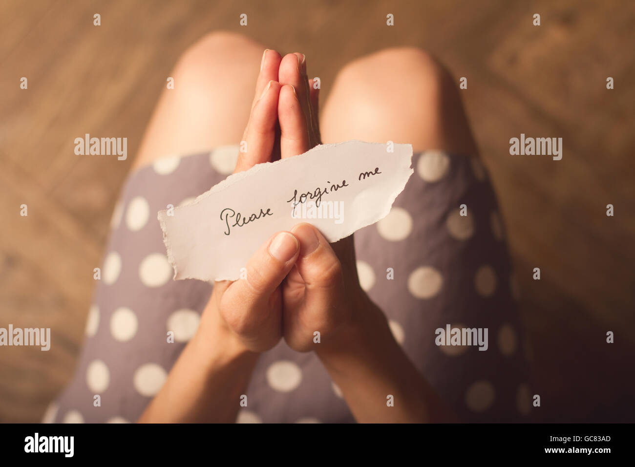 Top View of woman in dress holding avec un message papier avec le texte veuillez me pardonner Banque D'Images