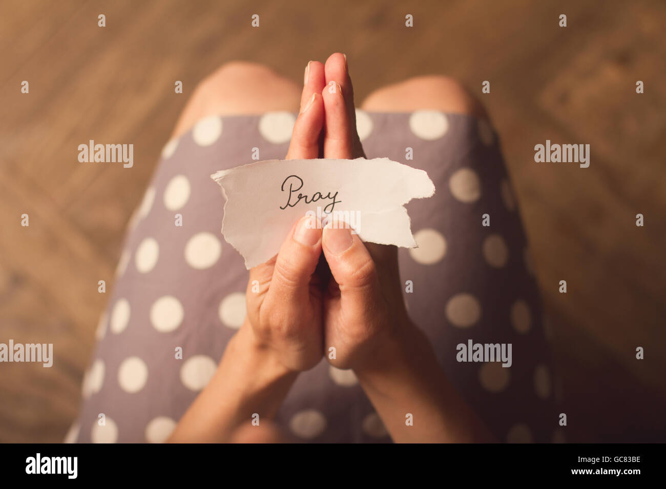 Top View of woman in dress holding avec un message papier avec le texte prier Banque D'Images