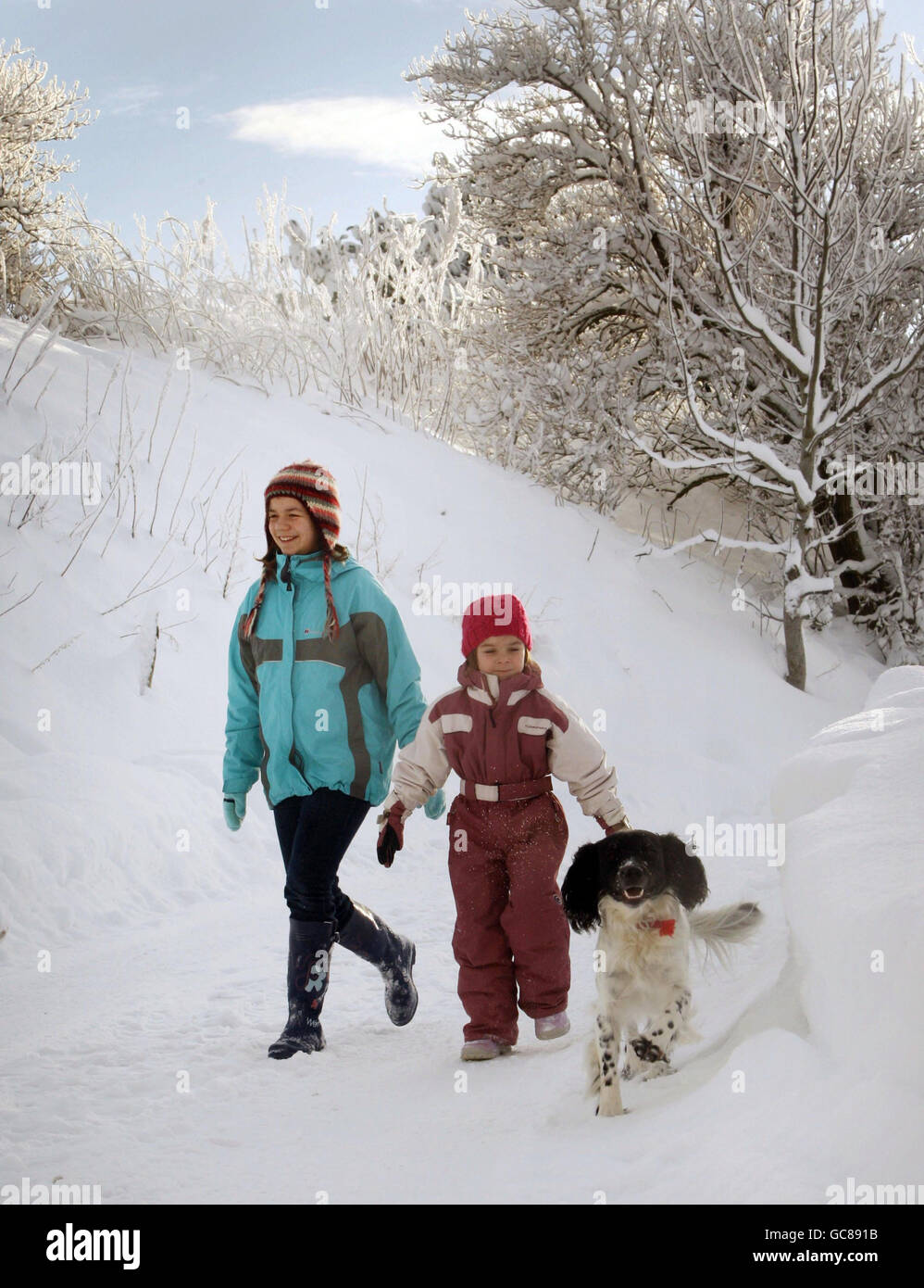 Les sœurs Jenny (à gauche) et Amy Wilson prennent Baxter le chien pour une promenade à Corvichen, en Écosse, alors que la neige et la glace continuaient de causer des ravages dans toute la Grande-Bretagne. Banque D'Images