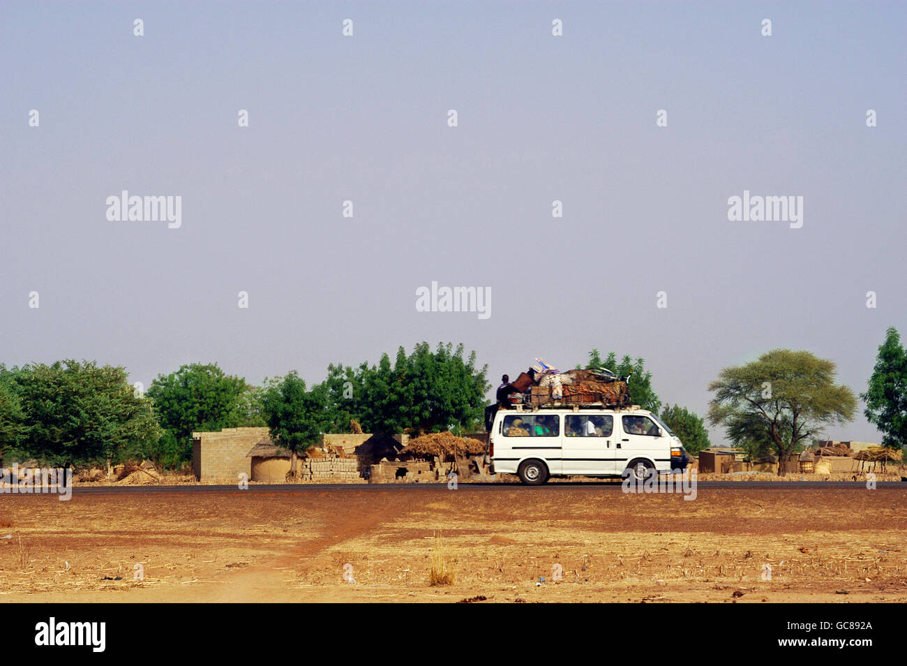 Un taxi sur la route de la ville de Koupéla vers la capitale Ouagadougou avec passagers et beaucoup de bagages Banque D'Images