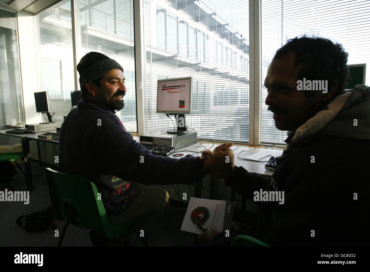 Suresh (à gauche) et son ami Maniyam (à droite), qui sont tous deux sans domicile depuis maintenant six mois, travaillent sur un ordinateur dans l'un des neuf centres temporaires de Londres mis en place par la crise de l'association caritative sans domicile, à Ivax Quays, Royal Docks, dans l'est de Londres. Banque D'Images