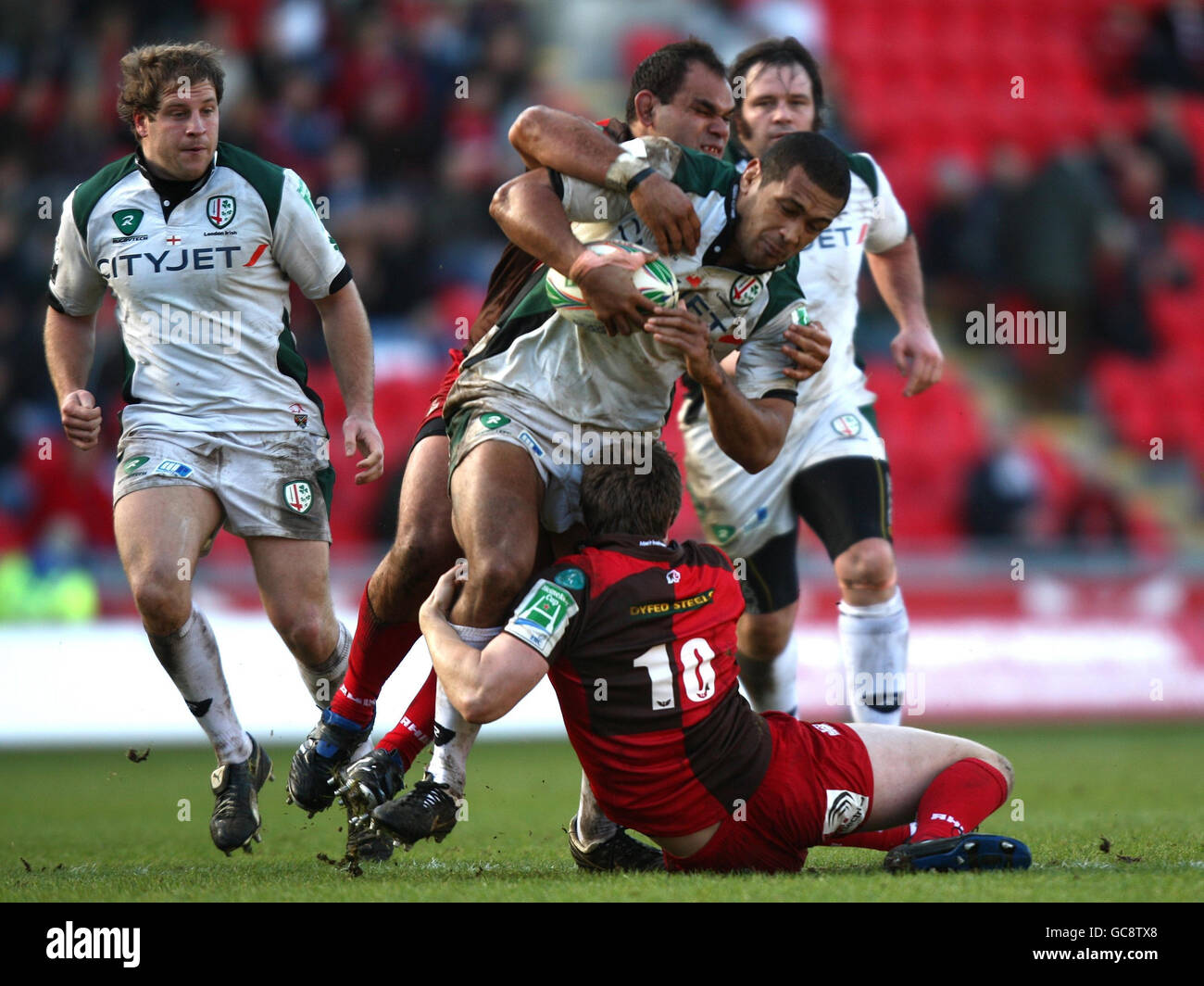 Chris Hala'ufia, de Londres, est attaqué par Scarlets Deacon Manu et Rhys Priestland lors du match de la coupe Heineken au parc y Scarlets, Llanelli. Banque D'Images